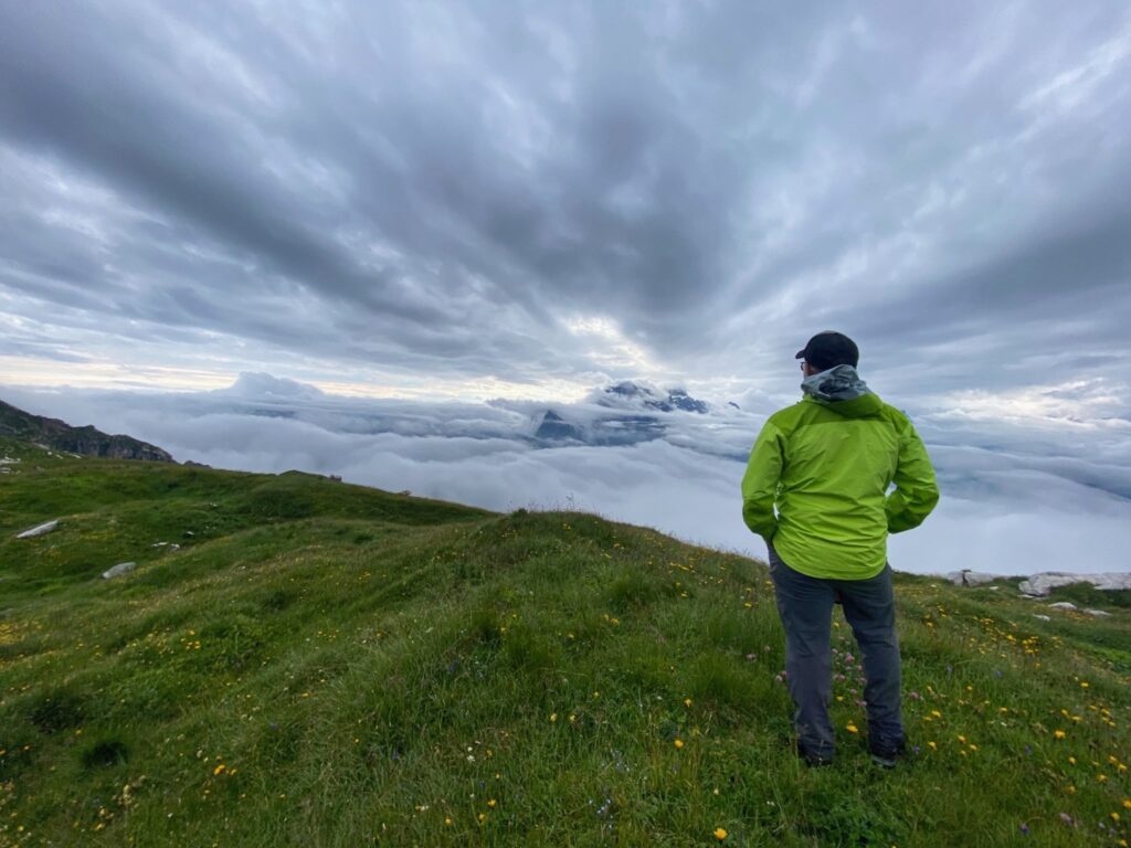 Lone man staring at mountains and clouds